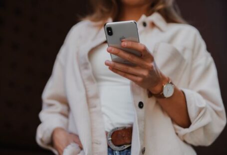 Smartphone - woman in white coat holding silver iphone 6