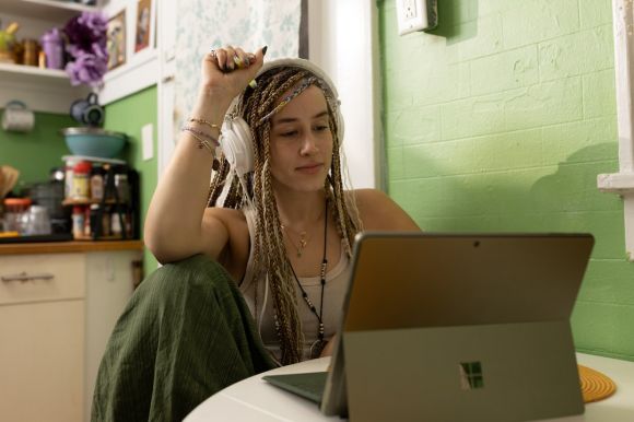 Laptop - a woman with dreadlocks sitting in front of a laptop computer