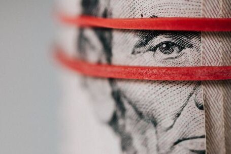 Power Banks - Closeup of rolled United States five dollar bills tightened with red rubber band