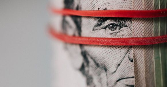 Power Banks - Closeup of rolled United States five dollar bills tightened with red rubber band