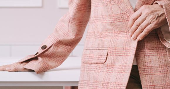 E-Readers - Woman in Pink and White Plaid Blazer Sitting on Brown Wooden Chair