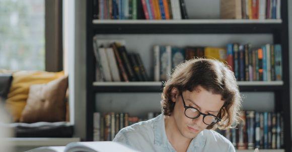 E-Readers - A Diligent Male Student Reading a Book