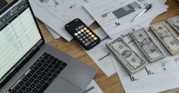 Wearable Payment Devices - Banknotes and Calculator on Table