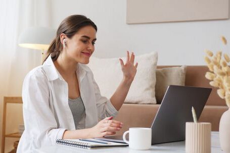 Wireless Earbuds - Cheerful woman having video call via laptop