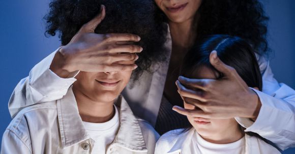 Parental Control Streaming - Mother covering eyes of her children with hands against internet content on digital pad