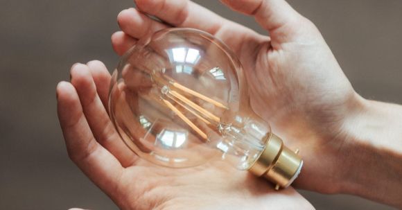Smart Lighting - Unrecognizable woman demonstrating light bulb in hands