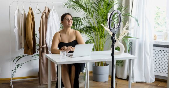 Vlogging Camera - A Woman in a Black Dress Vlogging Using a Cellphone and Ring Light