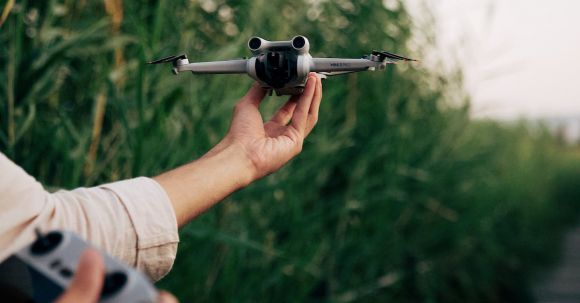 Photography Drone - Man Holding a Drone and a Controller