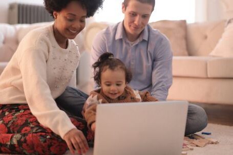 Wearable Tech For Parents - Photo of Family Sitting on Floor While Using Laptop