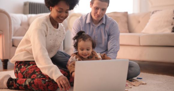 Wearable Tech For Parents - Photo of Family Sitting on Floor While Using Laptop